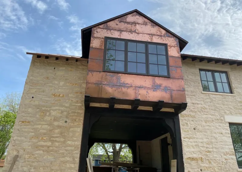 Copper metal panel facade on a stone building for Skylight Installation in Reidsville