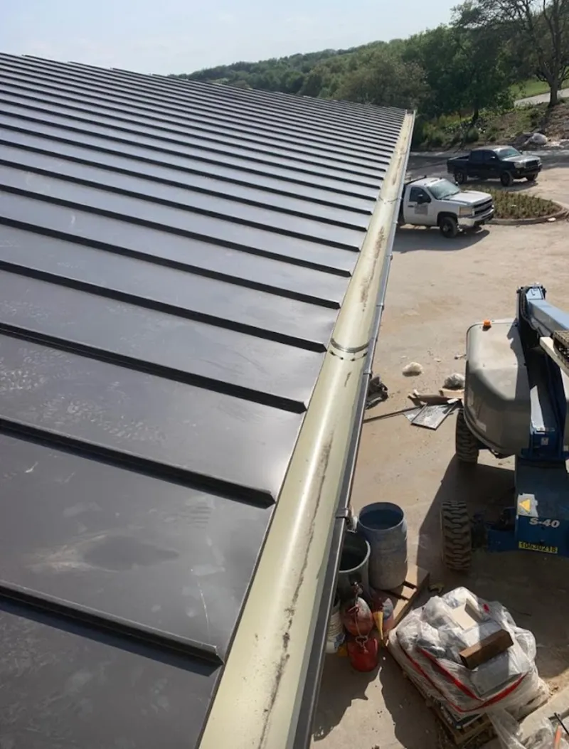 Standing seam panel and gutter detail on a metal roofing jobsite in Reidsville